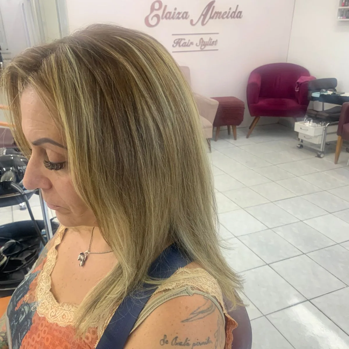 Loiro iluminado de frente, na cadeira do salão