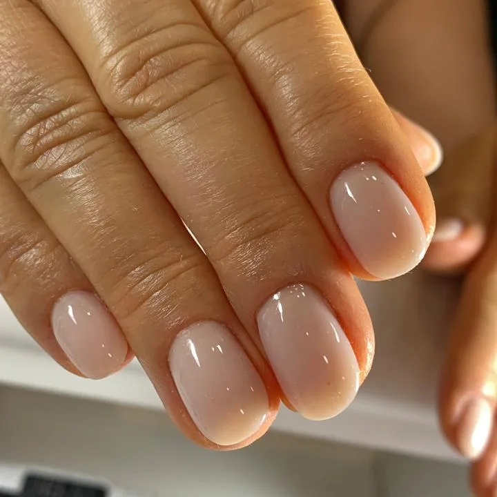 Unhas naturais curtas com esmalte nude leitoso